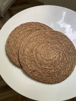 Темні круглі солом'яні підставки на стіл